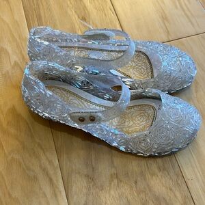 Clear jelly shoes with Velcro closure.